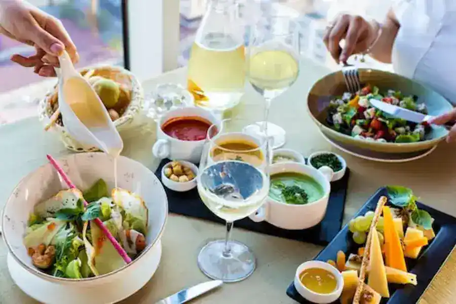 This promotional image showcases a delicious bowl of vegetable salad presented on a pristine white ceramic plate, accompanied by a sparkling wine glass. It is designed to entice visitors to explore the vibrant city of Houston and all that it has to offer.